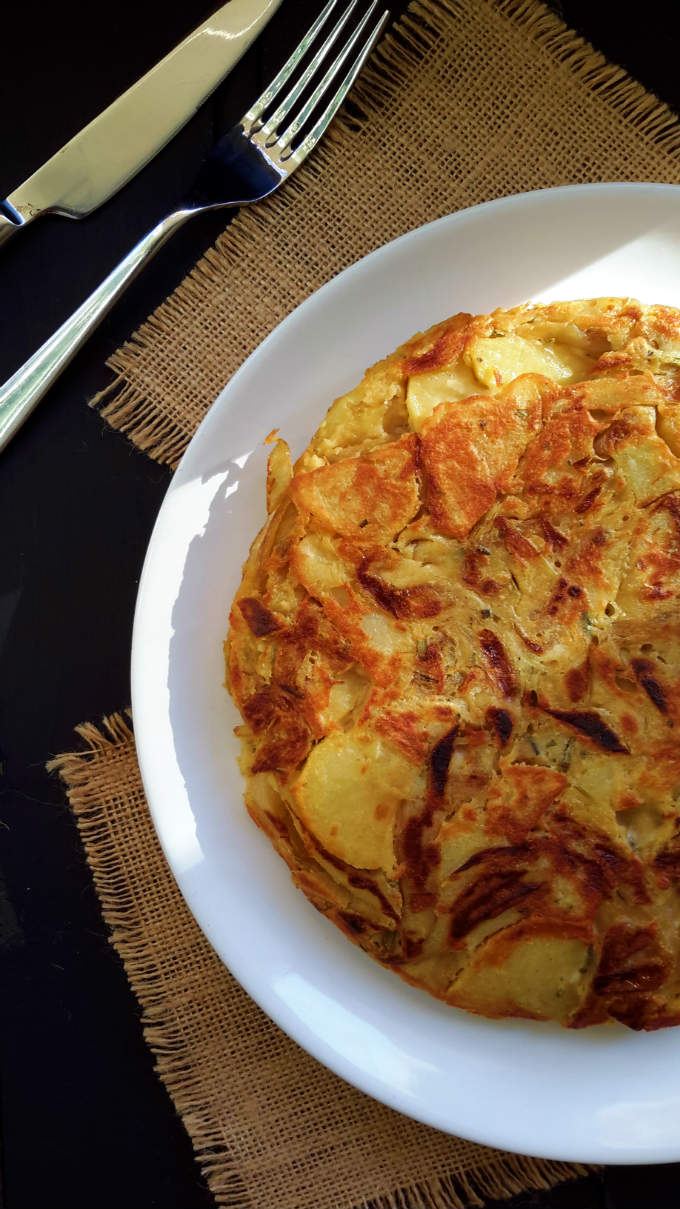 Vegan Spanish omelet with caramelized onions, roasted garlic and rosemary. An easy and delicious take on the traditional tortilla de patatas.