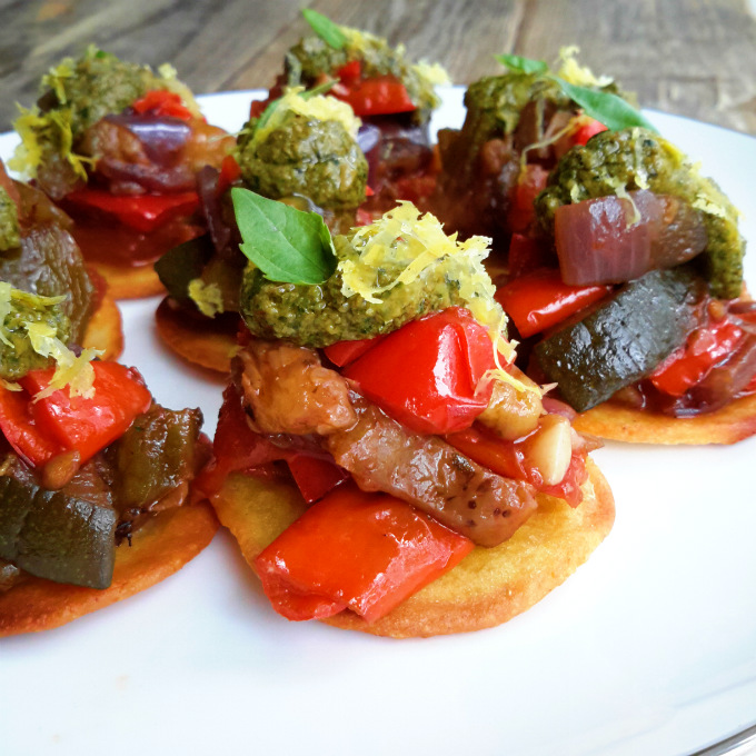 Ratatouille fresca y dulce servida sobre mini socca y decorado con pesto vegano. El plato vegetariano perfecto para servir de picoteo en tu proxima fiesta!